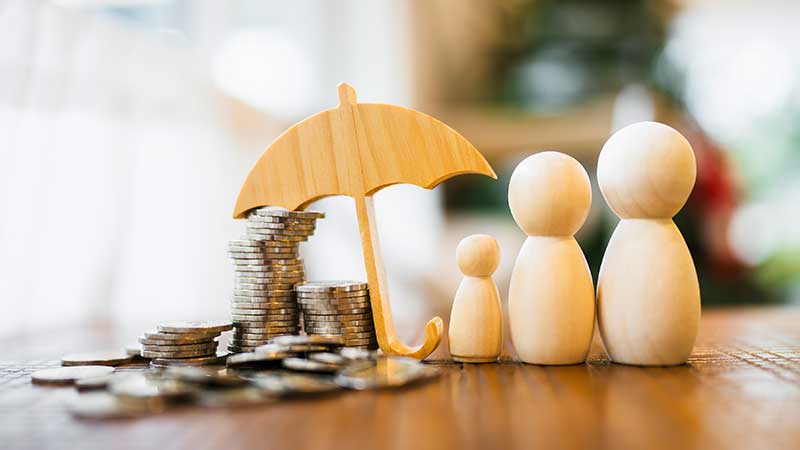 Três bonecos de madeira com guarda-chuva e moedas